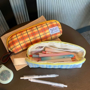 Detailed view of plaid fabric pencil pouches with zipper closure and mesh interior pockets