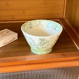 Detailed view of 5-inch ceramic bowl with lily of the valley floral patterns on a shelf