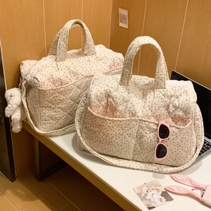 Close-up of floral quilted tote bags with reinforced handles and white plush charm