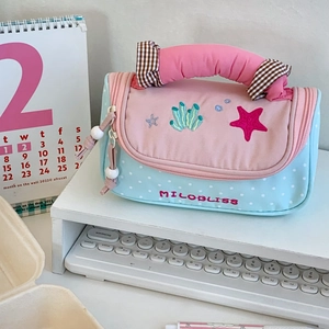 Detail of pink and blue polka dot stationery bag with sea element embroidery
