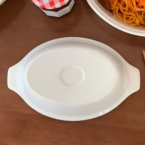 Detail view of the flat anti-slip bottom base on white ceramic oval baking dish
