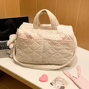 Close-up of quilted floral tote bag with brown flower patterns and plush charm detail