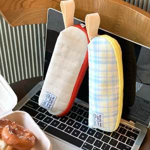 Detail of quilted white and checkered blue pencil cases featuring side carry handles