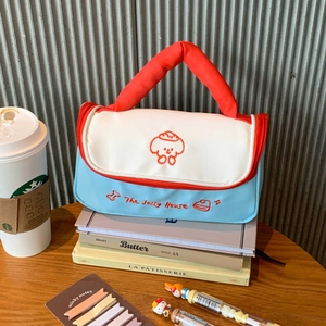 Detail of cute puppy cosmetic bag with embroidered text and contrast carrying handle