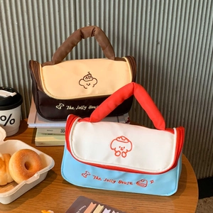 Detail of stitched canvas makeup bags with quilted handles and cute cartoon embroidery