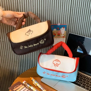 Handheld view of a large canvas makeup bag with puppy pattern and contrast handles