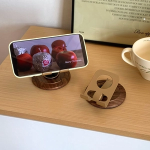 Detail of adjustable gold metal stand with wood grain base for phones and tablets