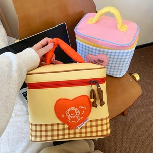 Close-up of insulated lunch bag with orange handles and brown checkerboard pattern