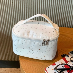Detail of white makeup bag with silver star pattern and metal dual zipper closure