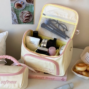 Grande trousse à maquillage beige avec fermetures roses et compartiments de rangement