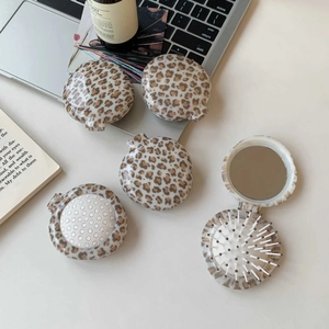Leopard print foldable travel hair brush and mirror set shown in a daily lifestyle scene