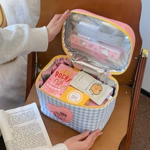 Close-up of blue plaid insulated lunch bag with pink heart embroidery and silver foil lining