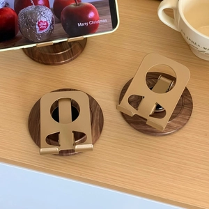 Close-up of vintage wood and gold metal phone stand in folded and unfolded positions