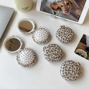 Detail of foldable leopard print hairbrush sets showing mirror and massage bristles