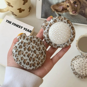 Detail view of the foldable leopard print hairbrush with integrated vanity mirror