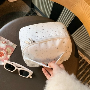 White canvas cosmetic bag with silver stars detail showing handle and large capacity