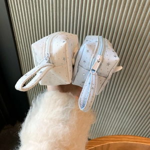 Detail of star pattern canvas pencil cases in white and light blue with carrying straps