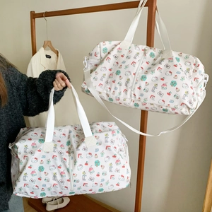 Detail of white travel bag with Hello Kitty pattern showing side mesh pocket and strap