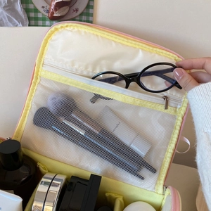 Détails de l'intérieur d'une trousse à maquillage rose avec rangements pinceaux