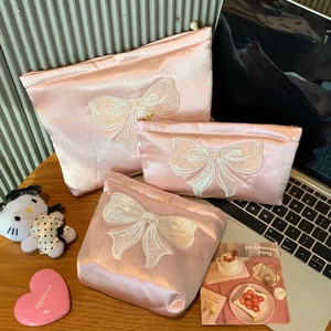 Détails des pochettes en satin rose avec broderie nœud et fermeture éclair en perles