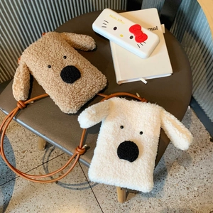 Detail von süßen Plüsch-Hundetaschen in Khaki und Cremeweiß mit weichem Fell