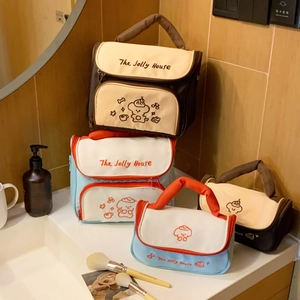 Detail of cute puppy embroidered cosmetics bag with sturdy handle and zipper closure
