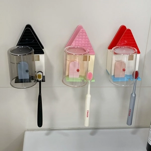 Dettaglio dei portaspazzolini a forma di casa a parete con tetti di vari colori