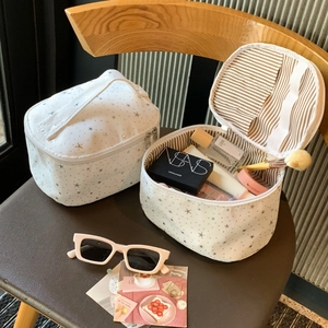 Detail of star pattern makeup bags with striped lining and specialized brush slots