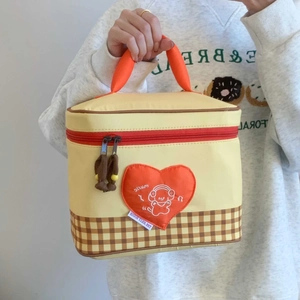 Close-up of insulated lunch bag with heart patch and bear design in hand