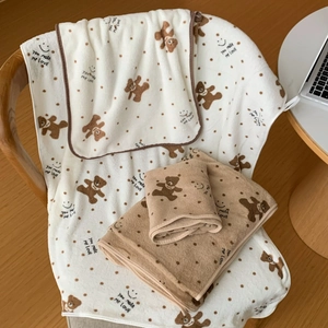 Detailed close-up of soft coral fleece towels with cute bear and polka dot prints