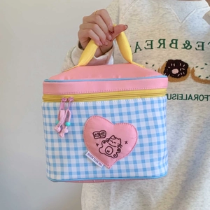 Detail of cute cartoon insulated lunch bag featuring blue checkered pattern and heart patch