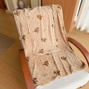 Detail of soft coral fleece towel featuring cute bear print and scalloped wave edges