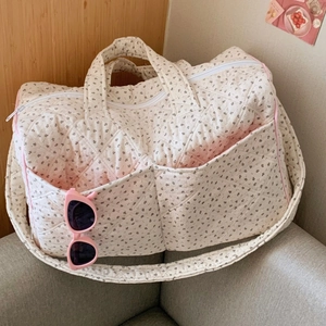 Quilted cotton tote bag with floral patterns showing dual straps and front pockets