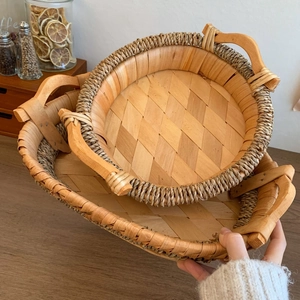 Close-up of woven rattan fruit trays with ergonomic wooden handles for home storage
