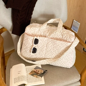 Quilted floral tote bag detail showing cotton texture and long shoulder strap design