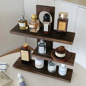 Detailed view of a dark solid wood three-tier display shelf with natural grain texture
