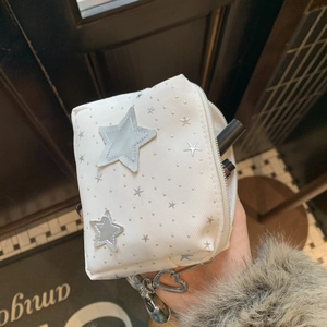 Close-up of white star pattern makeup bag with twill fabric and heart zipper pull