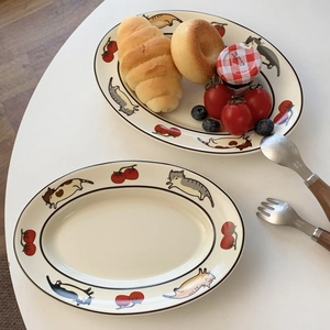 Détail de l'assiette ovale en céramique avec chats et tomates pour scènes de petit déjeuner