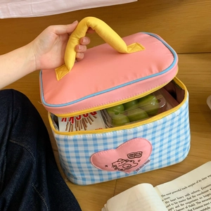 Close-up of insulated cartoon lunch bag with blue plaid and yellow handle showing interior space