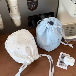Detail of star pattern drawstring bags in light blue and cream on a wooden table