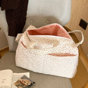 Floral quilted tote bag detail showing pink lining and multi-pocket storage design