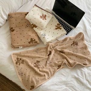 Close-up of thick coral fleece towels with teddy bear print and soft fluffy texture
