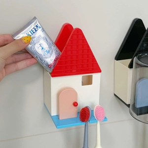 Dettaglio del portaspazzolino a parete a forma di casa con due fessure e scomparto
