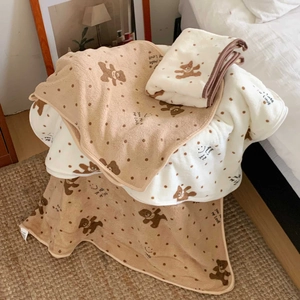 Detailed close-up of soft coral fleece bear and polka dot towel set with embroidery