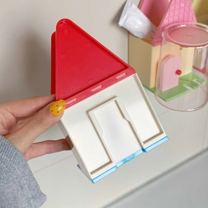 Dettaglio del portaspazzolino a forma di casa in plastica rossa, bianca e blu vivace