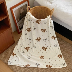 Detail of coral fleece towel set featuring cute brown bear patterns and polka dots