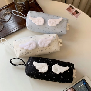 Detailed view of canvas pencil cases with plush angel wings and starry silver patterns