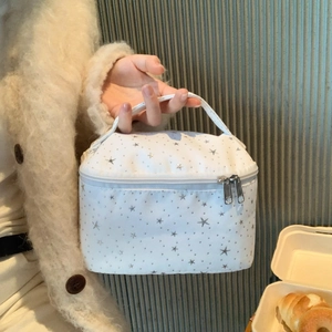 Close-up of white star pattern makeup bag with handle and metal dual zippers
