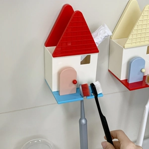 Dettaglio del portaspazzolino a forma di casa colorata con ganci per riporre accessori