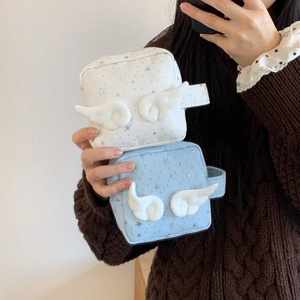 Detail von tragbaren Sternen-Make-up-Taschen mit 3D-Engelsflügeln von einem Model gehalten